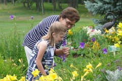woman in a flower garden with her granddaughter