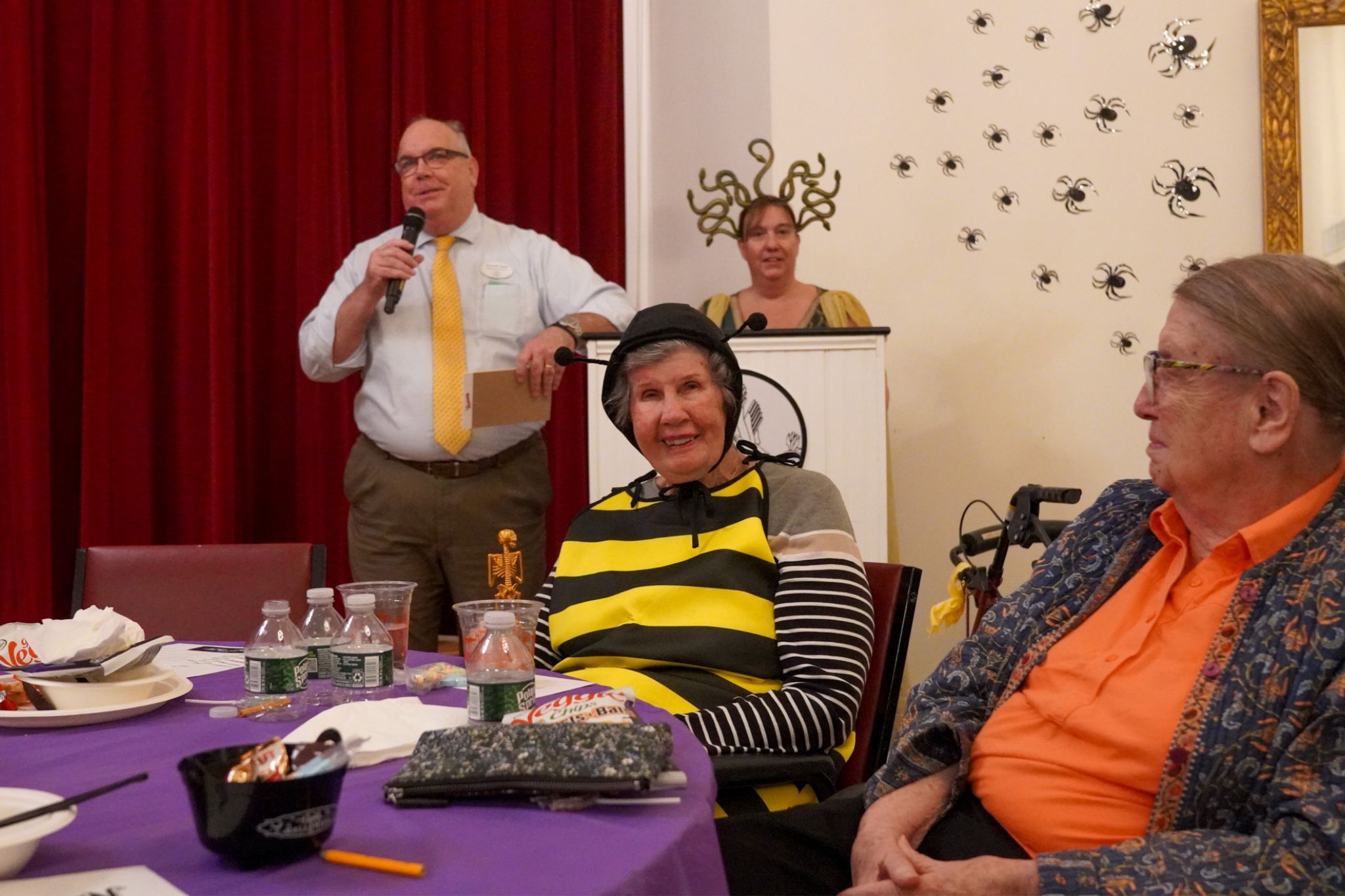 A group of people in a room discusses scholarship opportunities and academic achievements.