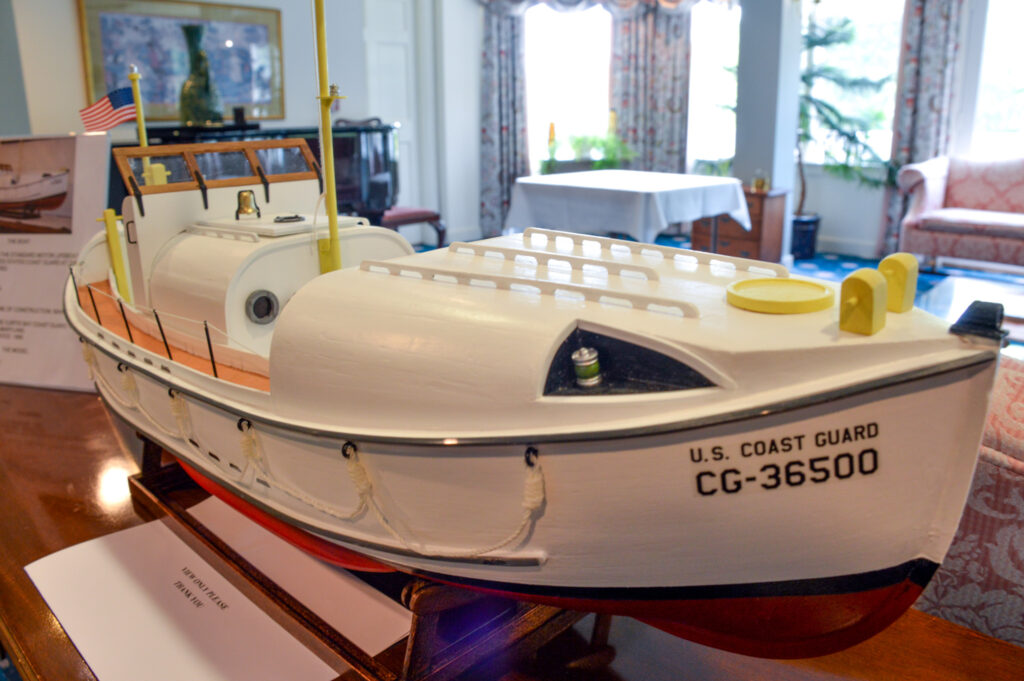 A meticulously crafted model of the U.S. Coast Guard boat, CG-36500, is elegantly displayed indoors on a wooden table, evoking a sense of maritime history that resonates with the nostalgia often cherished in senior living communities.