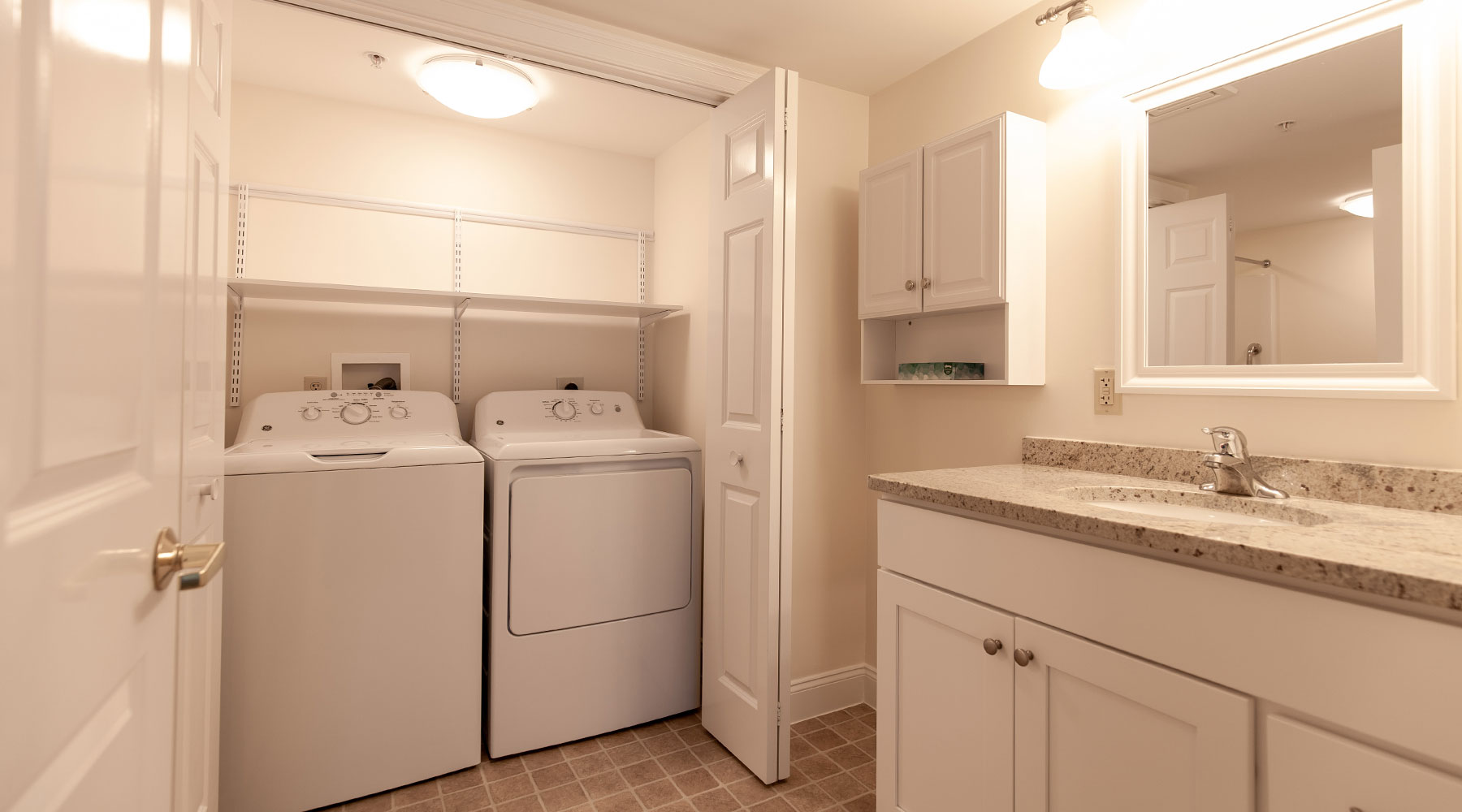 white bathroom with open closets showing a wash and dryer