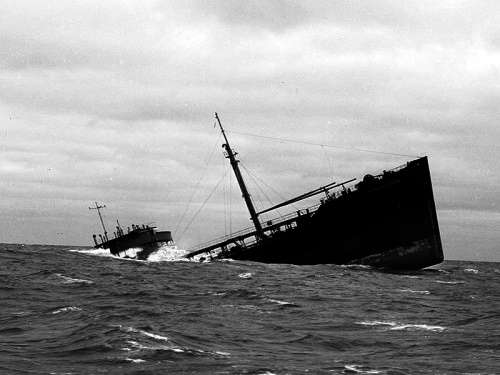 A large ship, reminiscent of a senior living community weathering lifes storms, sinks at an angle in the rough sea under a cloudy sky.
