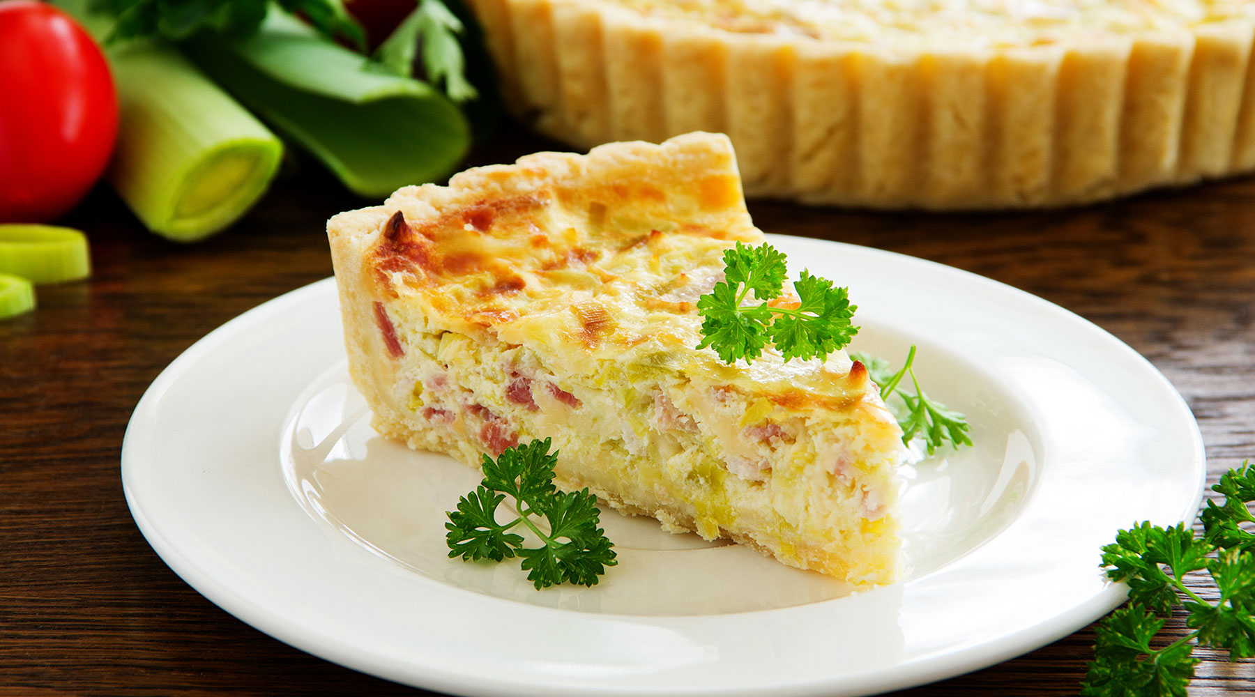 a slice of quiche on a white plate
